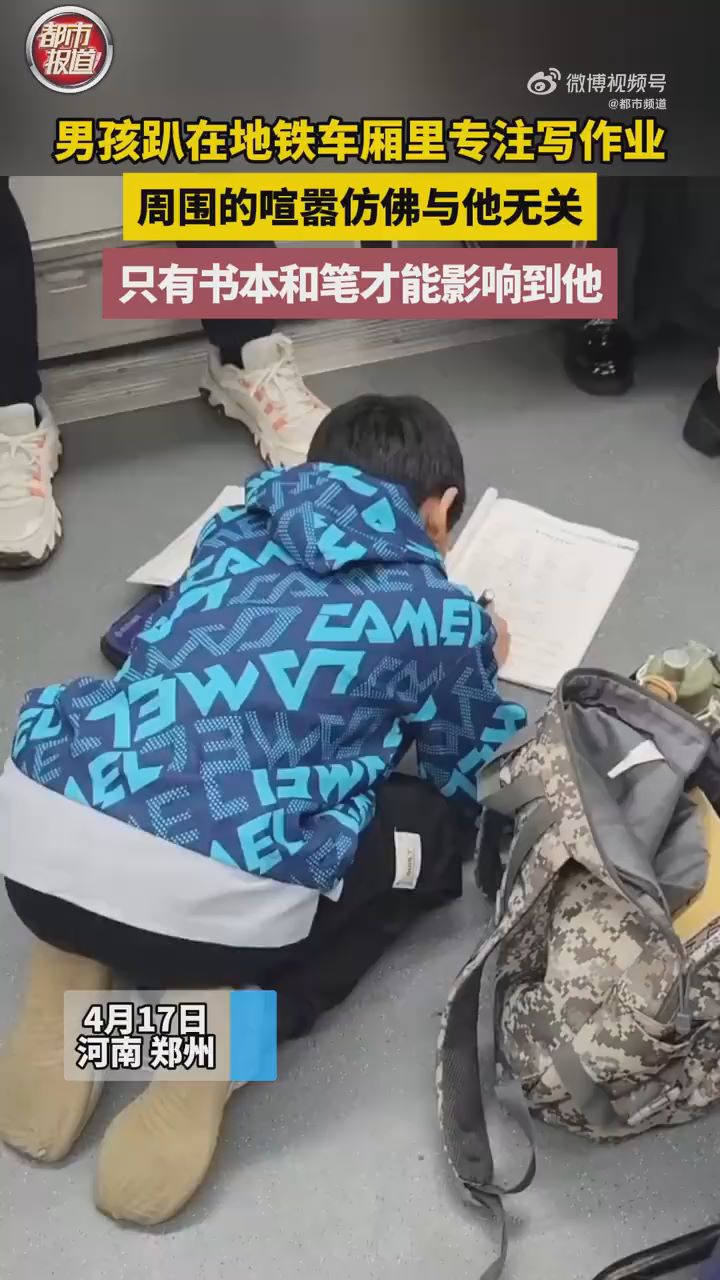 男孩趴在地铁里专注写作业
