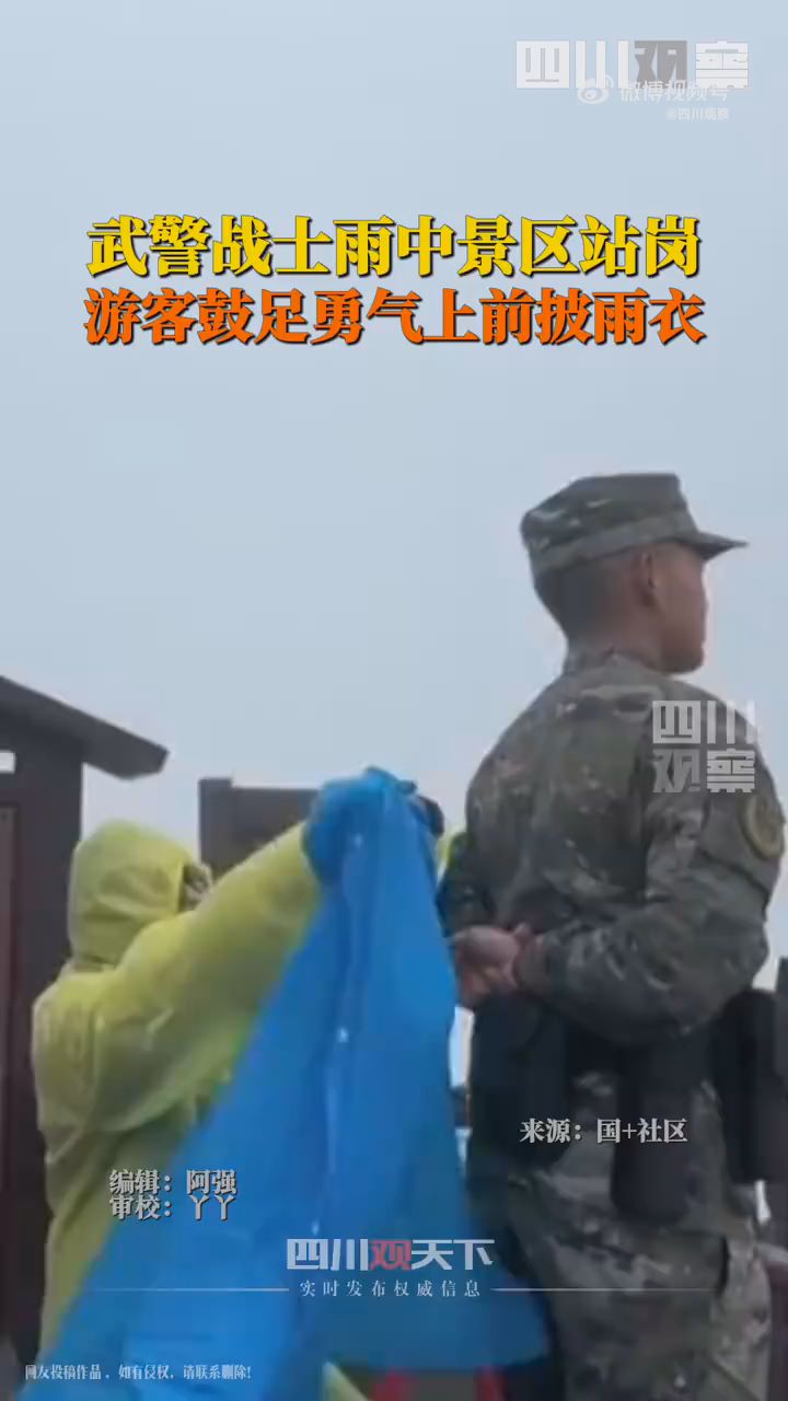游客为雨中站岗武警披上雨衣
